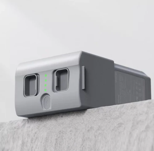 Unitree G1 battery resting on a stone surface with green LED charge level indicators lit, showing the quick-release latches and power button